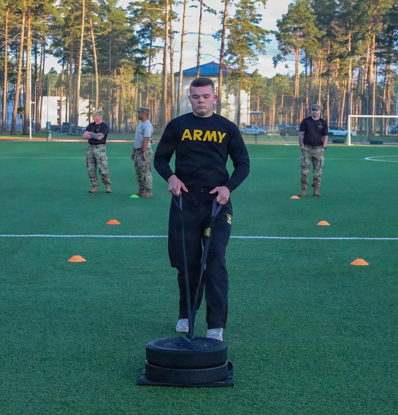 Een militair trekt een gewichtsslee tijdens een fitnesswedstrijd op de militaire basis Ādaži in Letland, de basis waar de NAVO-technologie-experimenten plaatsvinden.